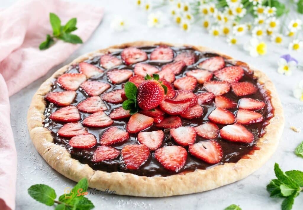 صورة 3: Pizza dessert chocolat fraise – pizza choco-fraise sur planche avec fleurs et menthe