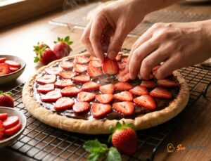 Pizza choco-fraise sortie du four avec fraises caramélisées sur ganache brillante