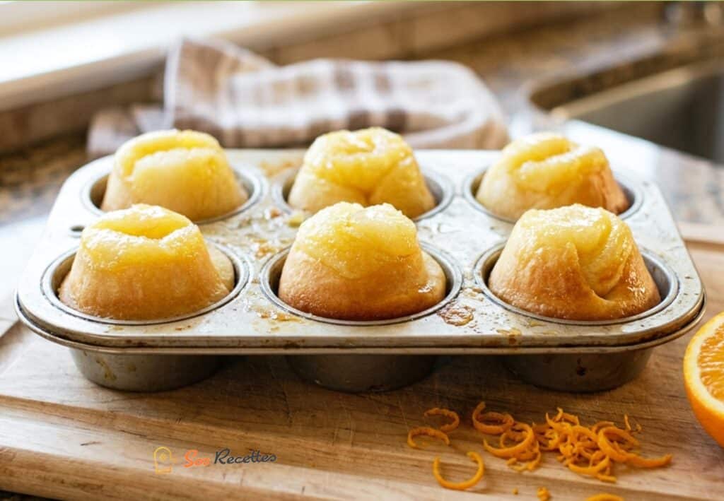 Roulés d'orange dans un moule à muffins avec demi-orange et zestes – recette SosRecette